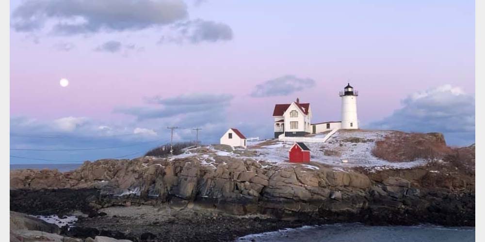 Nubble Light at Sunrise with moon in sky